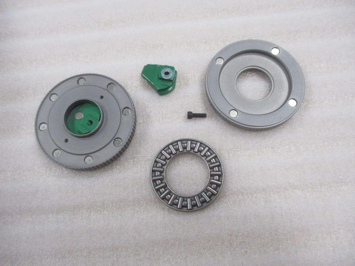 A coin taken apart: the wheel, the toggle, the bearing and the cover
